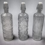 Fume Colored Glass Bottle with Embossed Designs and Hermetic Cover
