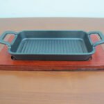Large rectangular cast iron sizzling with wooden base