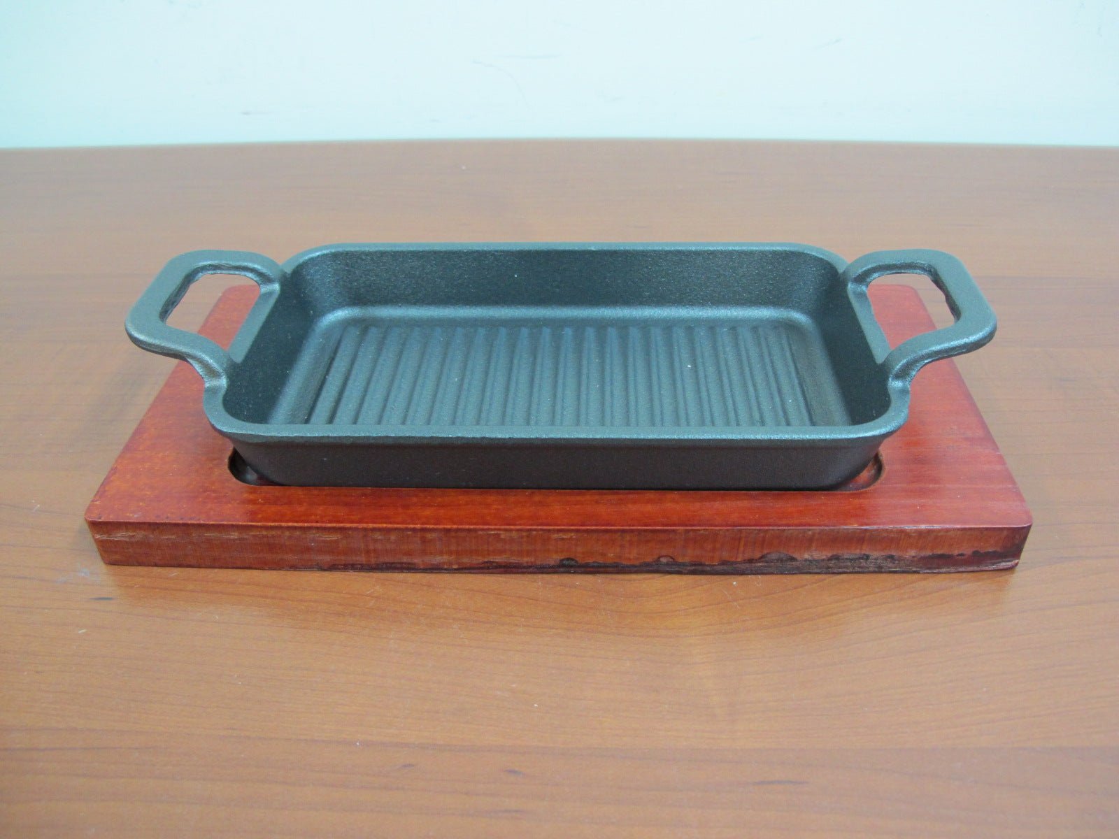 525a407e7df3ac85dc6181f426acfcbd.jpg Large rectangular cast iron sizzling with wooden base